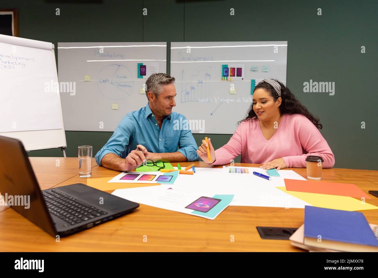 Multiracial businessman and businesswoman discussing strategy over documents in creative office Stock Photo