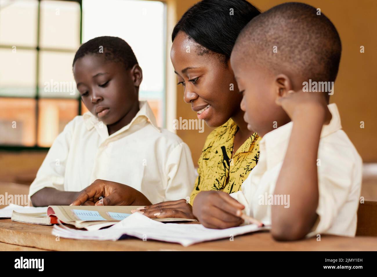 Teacher helping kids class Stock Photo