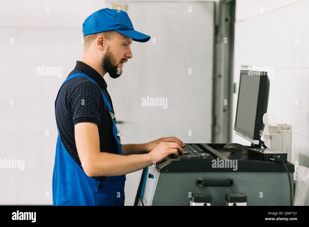 Technician typing keyboard garage Stock Photo Alamy