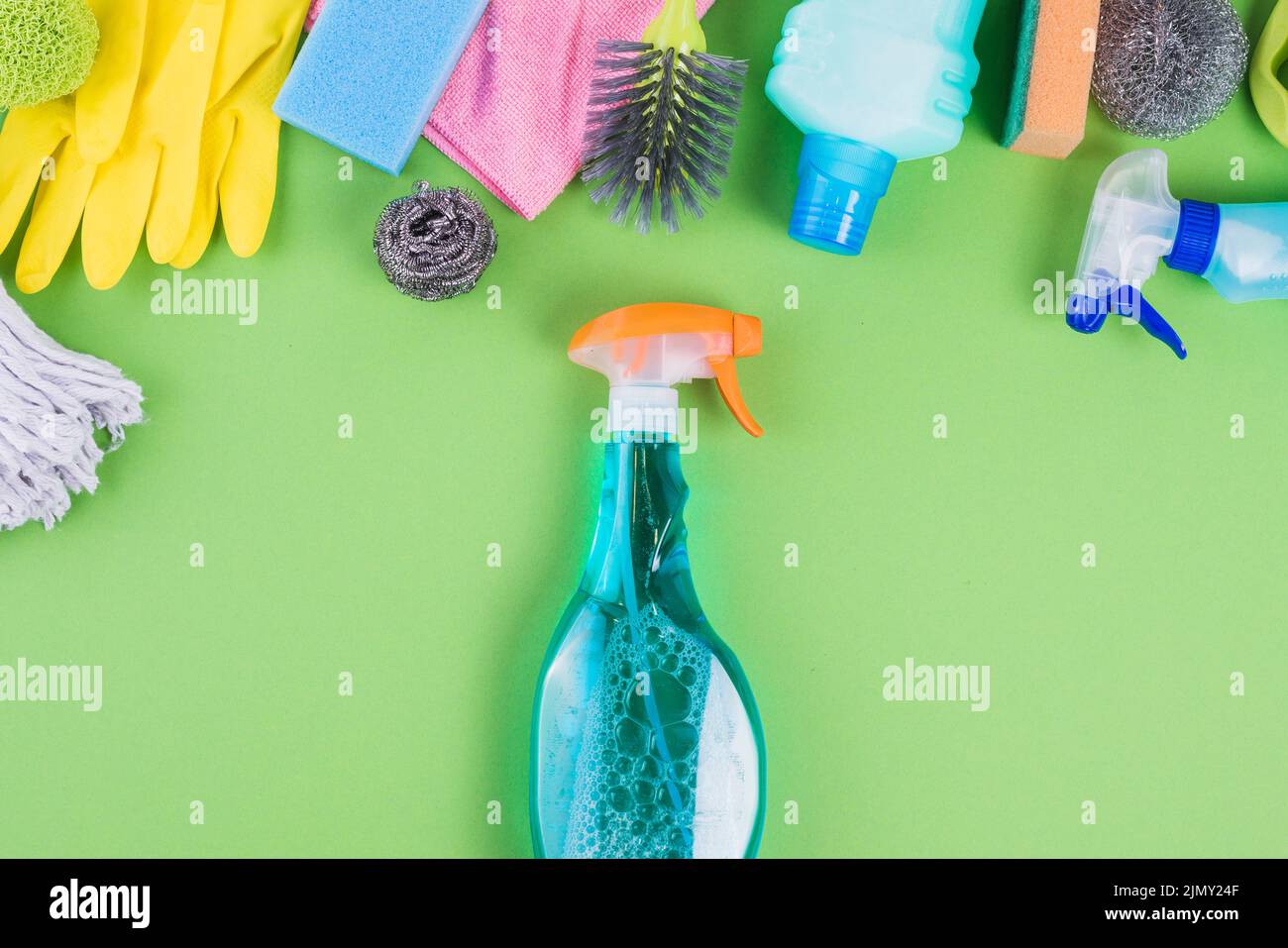 Spray bottles with blue liquid near various cleaning equipments Stock Photo