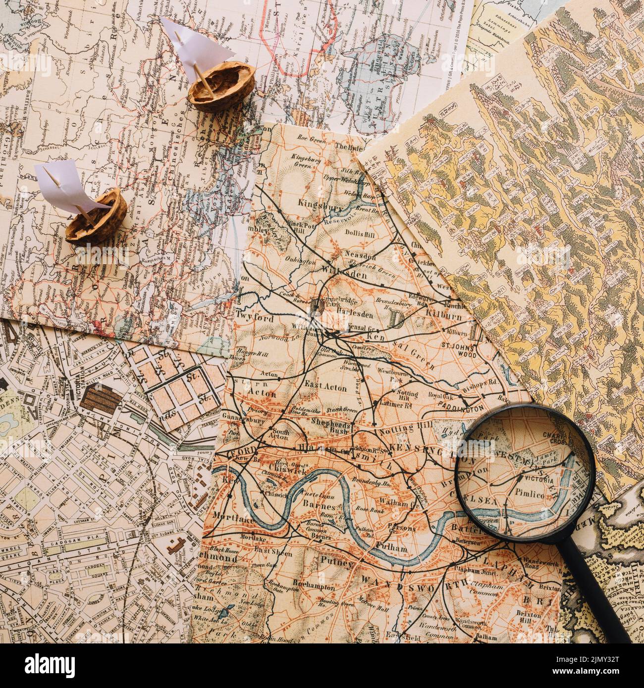 Nutshell boats magnifying glass maps Stock Photo
