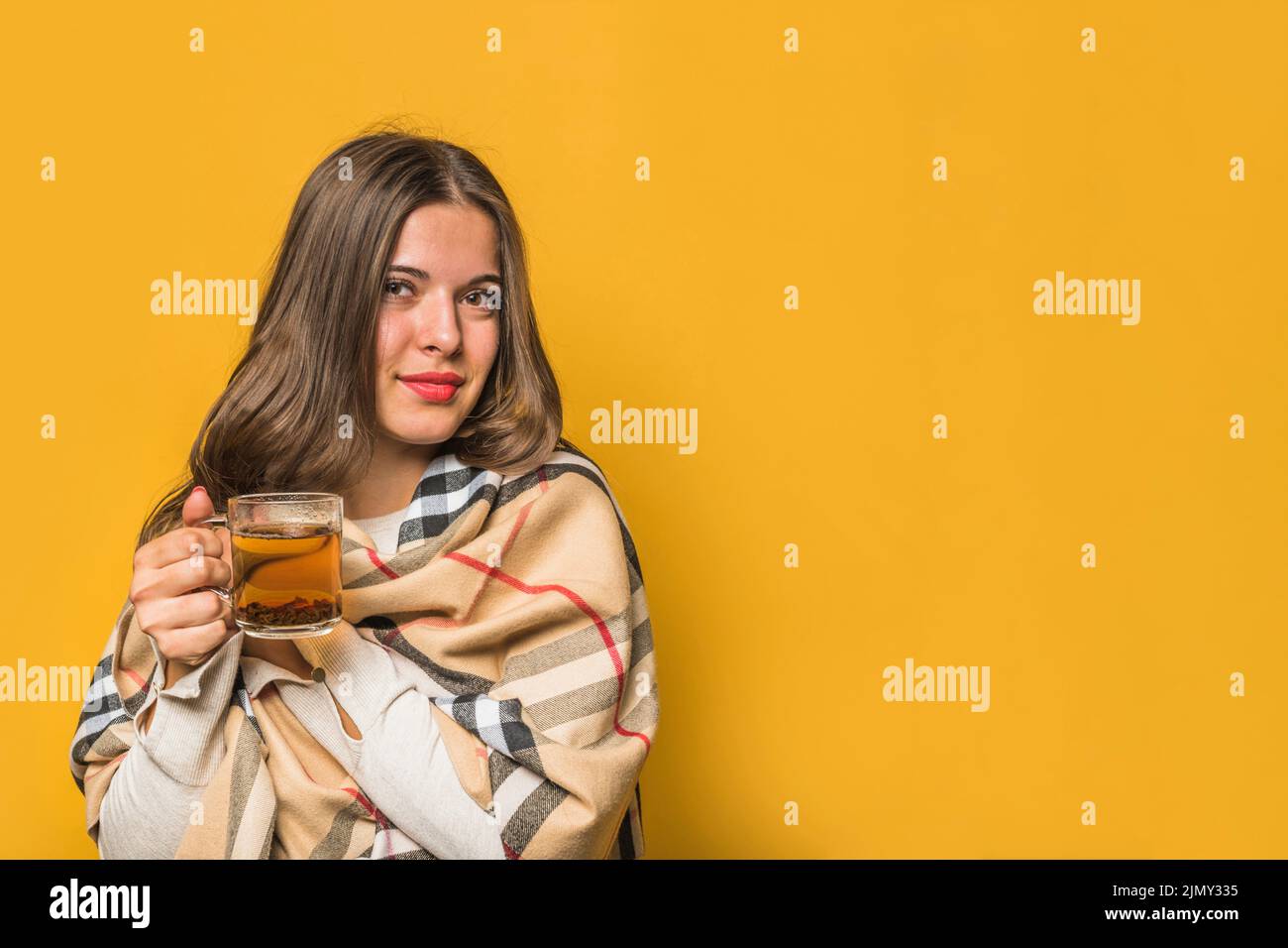 Portrait young woman wrapped shawl holding herbal tea cup Stock Photo