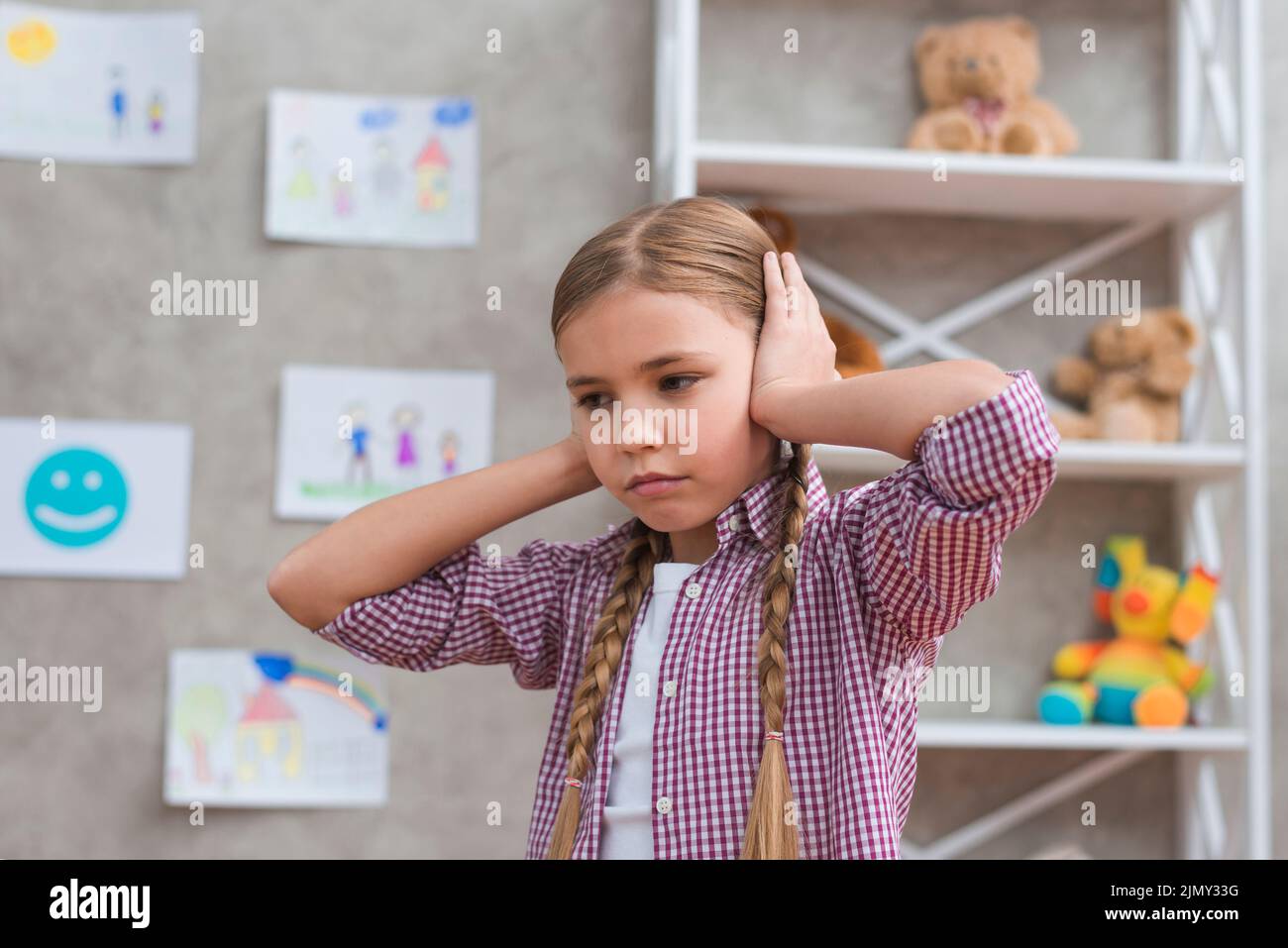 Portrait sad girl covering her ears with two hands Stock Photo