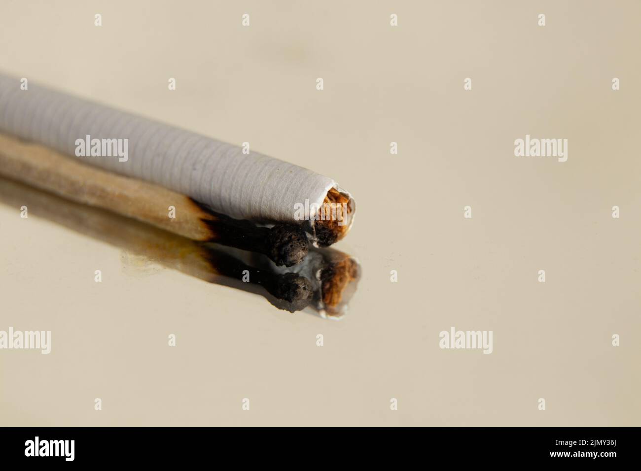 cigarettes and a burnt match on an isolated background, cigarettes and bad habits, smoking Stock Photo