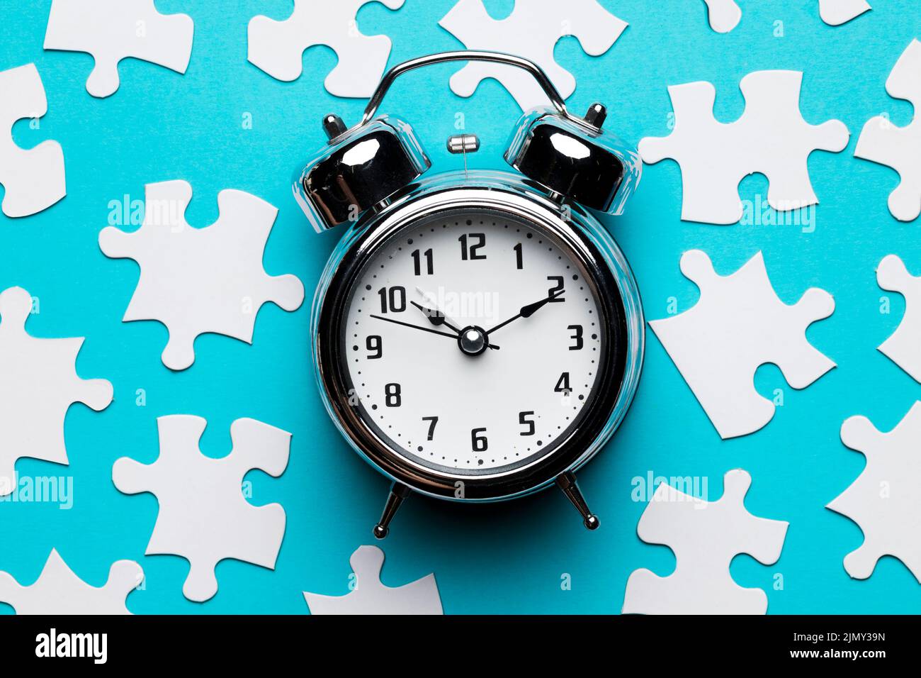 Retro alarm clock jigsaw puzzle pieces blue backdrop Stock Photo Alamy