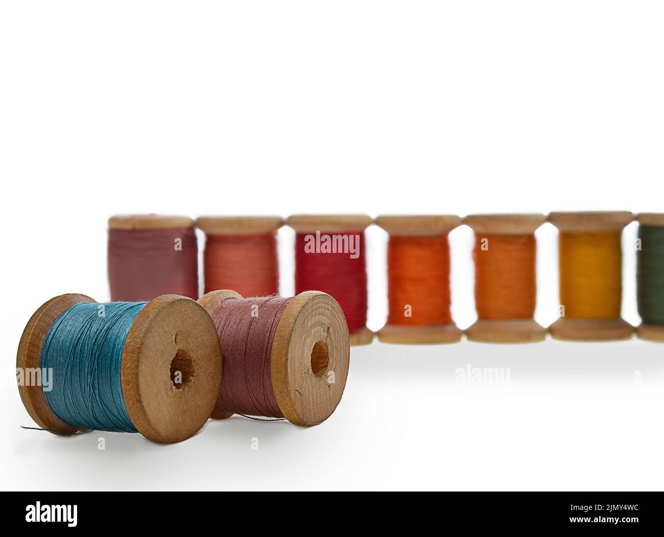Spools of wooden thread. Blue and lilac lie, red stand in a row. Sewing, repairing clothes. Copy space Stock Photo