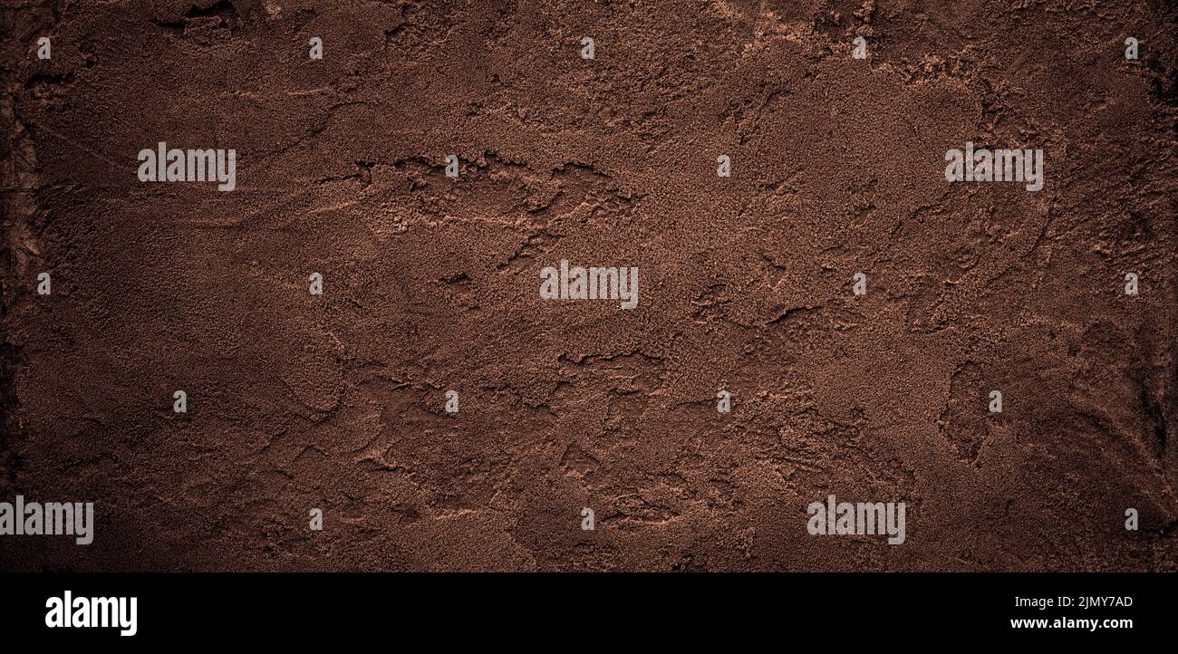 Dark chocolate brown sugar-like grainy texture background Stock Photo