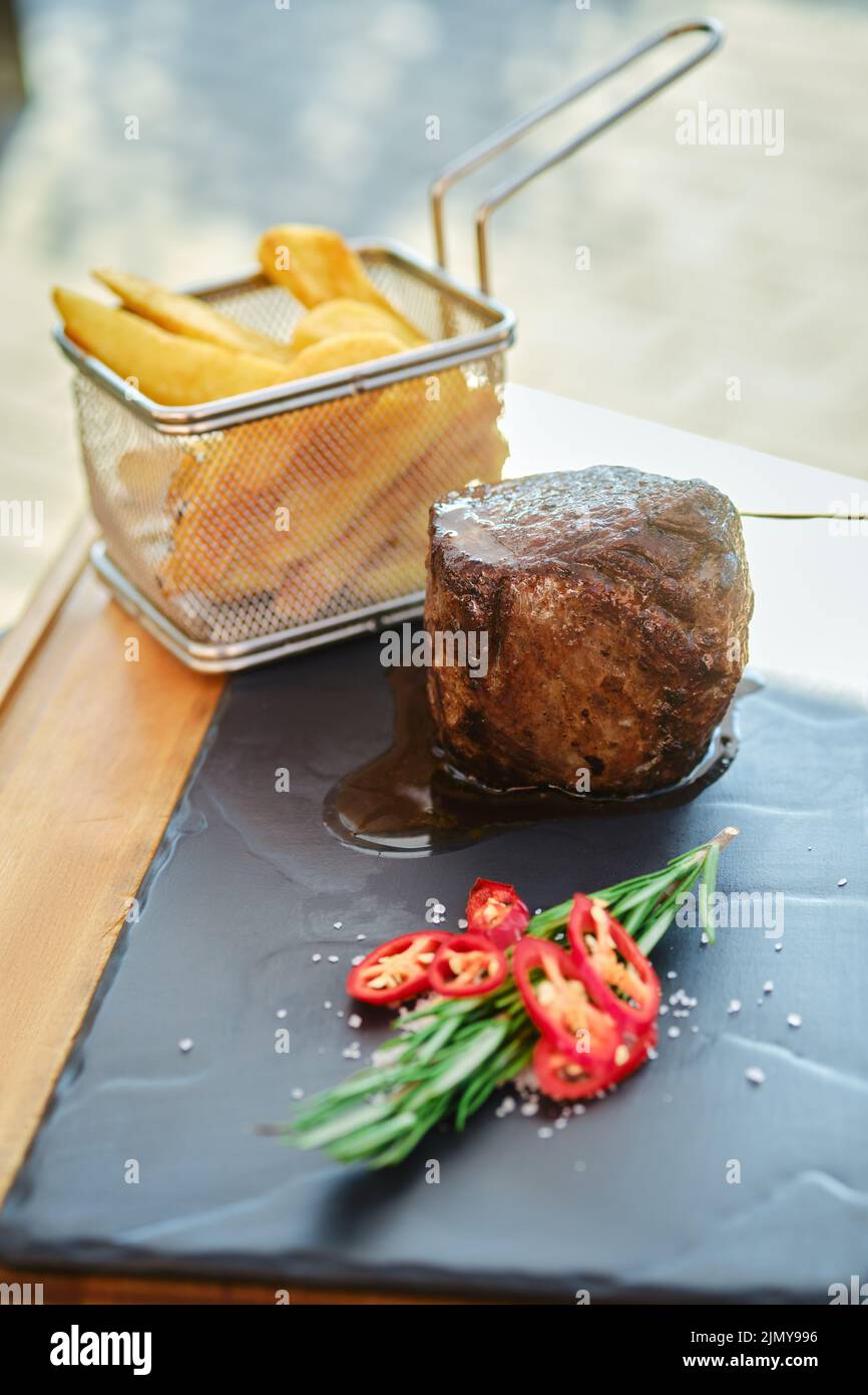 Grilled fillet mignon and french fries on slate plate Stock Photo