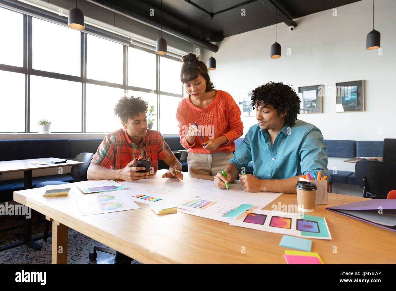 Creative multiracial design professionals discussing strategy at table in office Stock Photo
