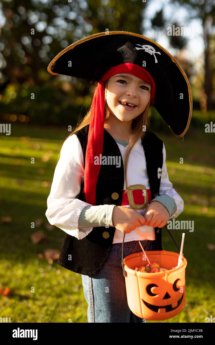 Vertical image of happy caucasian boy in pirate costume in autumn ...