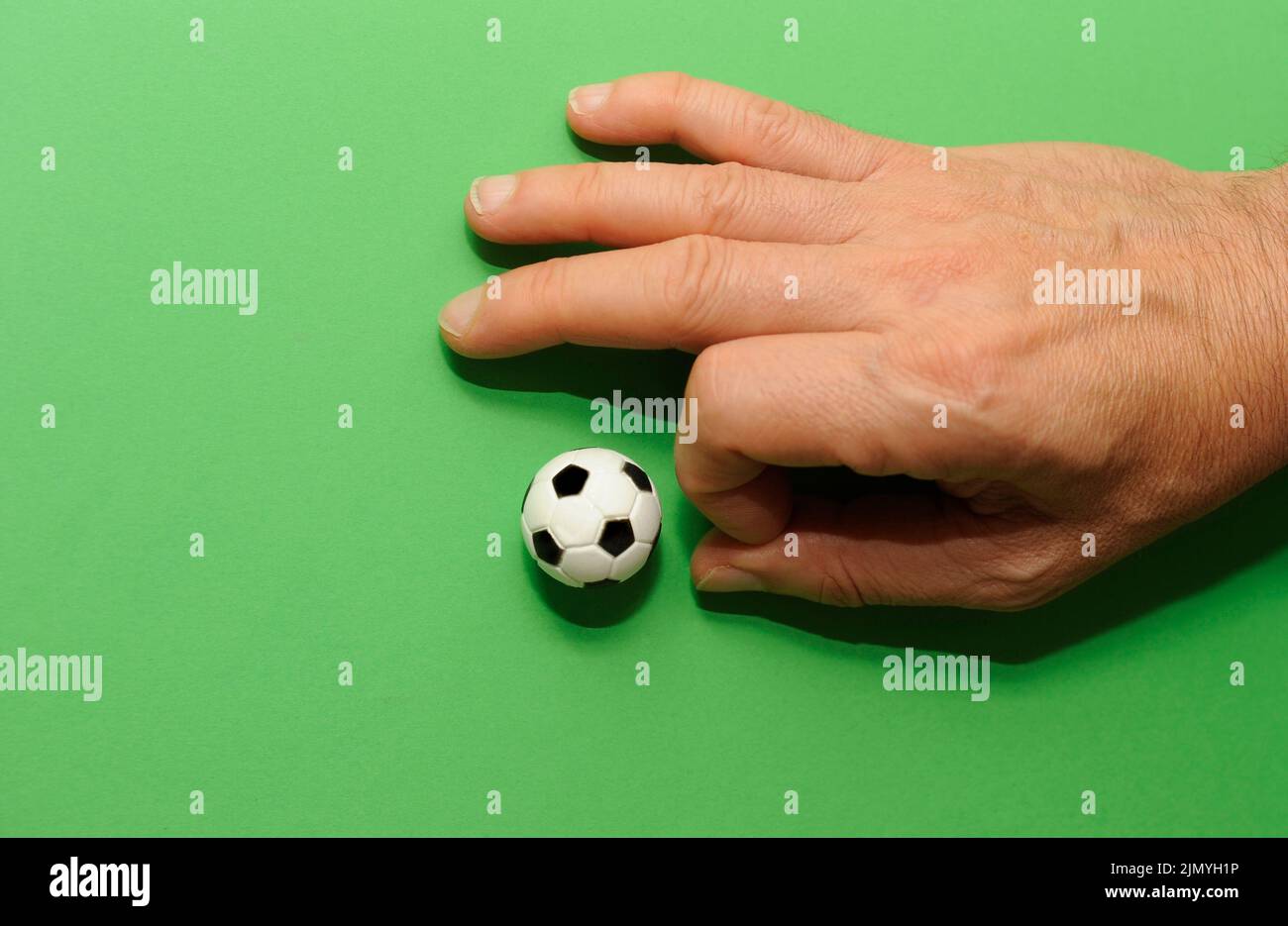 male hand finger football with a miniature toy soccer ball Stock Photo