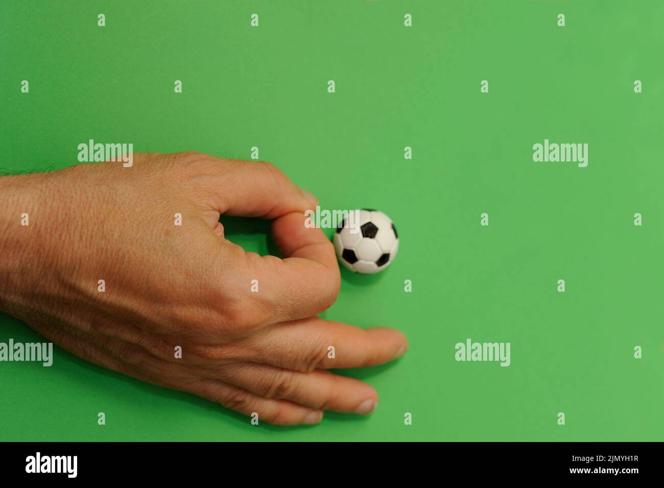 male hand finger football with a miniature toy soccer ball Stock Photo
