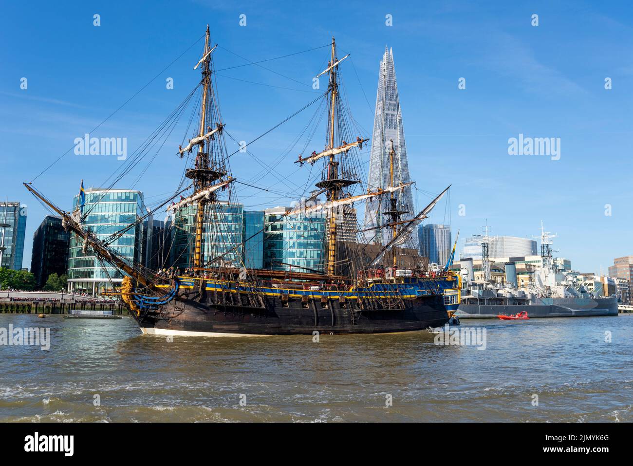 Tower Bridge, London, UK. 8th Aug, 2022. Gotheborg of Sweden is a sailing replica of the Swedish East Indiaman Gotheborg I, launched in 1738, and is visiting London to welcome visitors on board. The wooden replica ship was launched in 2003 and last visited London in 2007. It has navigated up the River Thames in the morning to pass under the opened Tower Bridge before turning and passing back under and heading for Thames Quay in Canary Wharf, where it will be open to visitors. Passing HMS Belfast, The Shard and More London buildings Stock Photo
