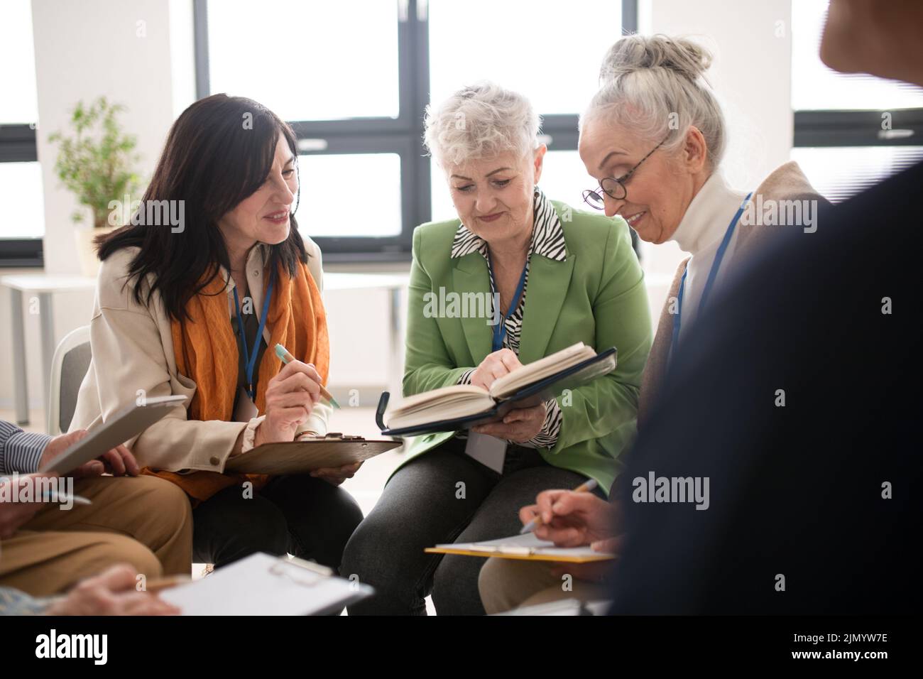 Group of seniors with singing books together at choir rehearsal. Stock Photo