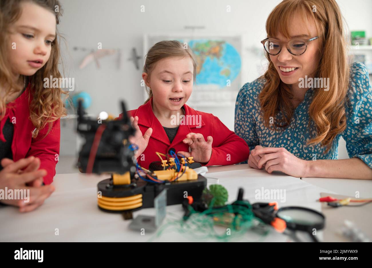 Group of kids with young science teacher programming electric toys and robots at robotics classroom Stock Photo