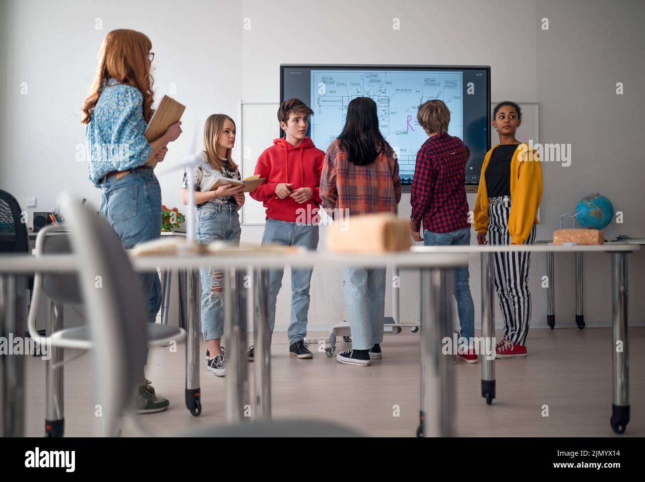 College student explaining some ideas on a touch TV in classroom. Stock Photo