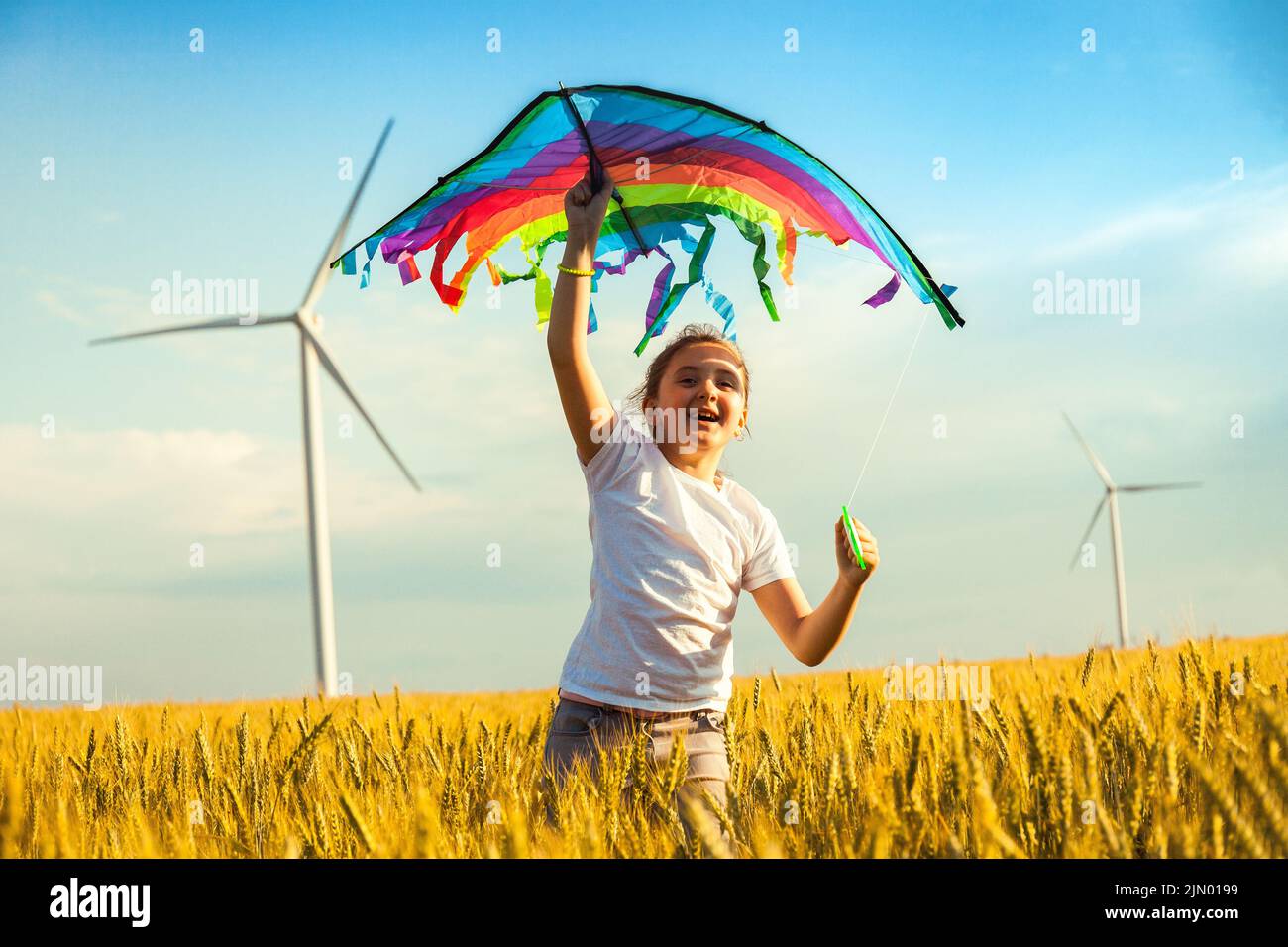 Happy Little girl running in a wheat field with a kite in the summer ...