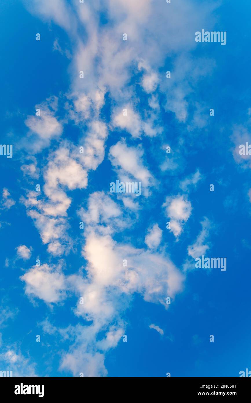 Blue sky with light white fluffy clouds suitable for sky replacement.  Focal length: 24mm; aperture: f/6.3 Stock Photo