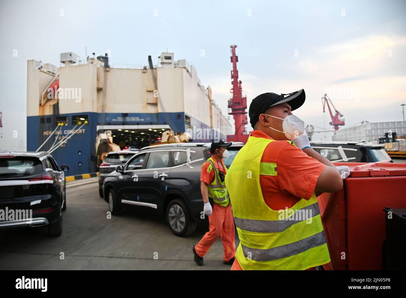 Qingdao, China's Shandong Province. 7th Aug, 2022. Staff work during the shipment of commercial vehicles onto a ro-ro cargo vessel to depart for Africa at Qingdao Port in Qingdao, east China's Shandong Province, Aug. 7, 2022. By far this year, the export volume of commercial vehicles from Qingdao Port has grown over 90 percent on year-on-year basis. Credit: Li Ziheng/Xinhua/Alamy Live News Stock Photo