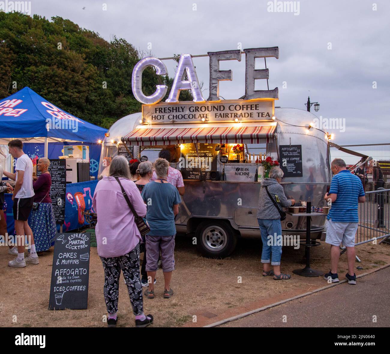 Pop up cafe caravan with broken illuminated sign. Outdoor eating and coffee, festival stall. Cafe sign.coffee Stock Photo
