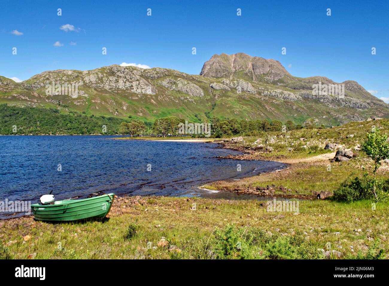 SLIOCH MOUNTAIN WESTER ROSS SCOTLAND IN SUMMER A GREEN FISHING BOAT AND A BLUE LOCH MAREE Stock Photo