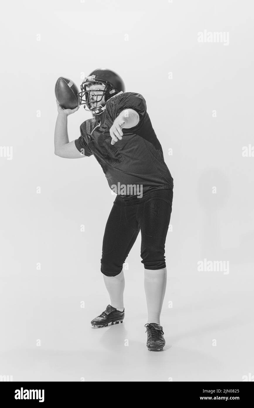 Black and white portrait of american football player in vintage style sports uniform isolated on white background. Monochrome Stock Photo