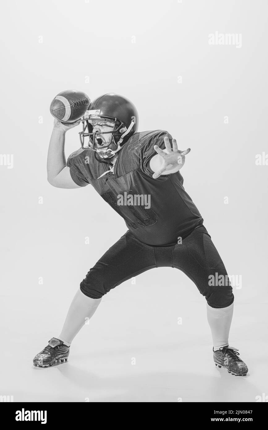 Black and white portrait of american football player in vintage style sports uniform isolated on white background. Monochrome Stock Photo