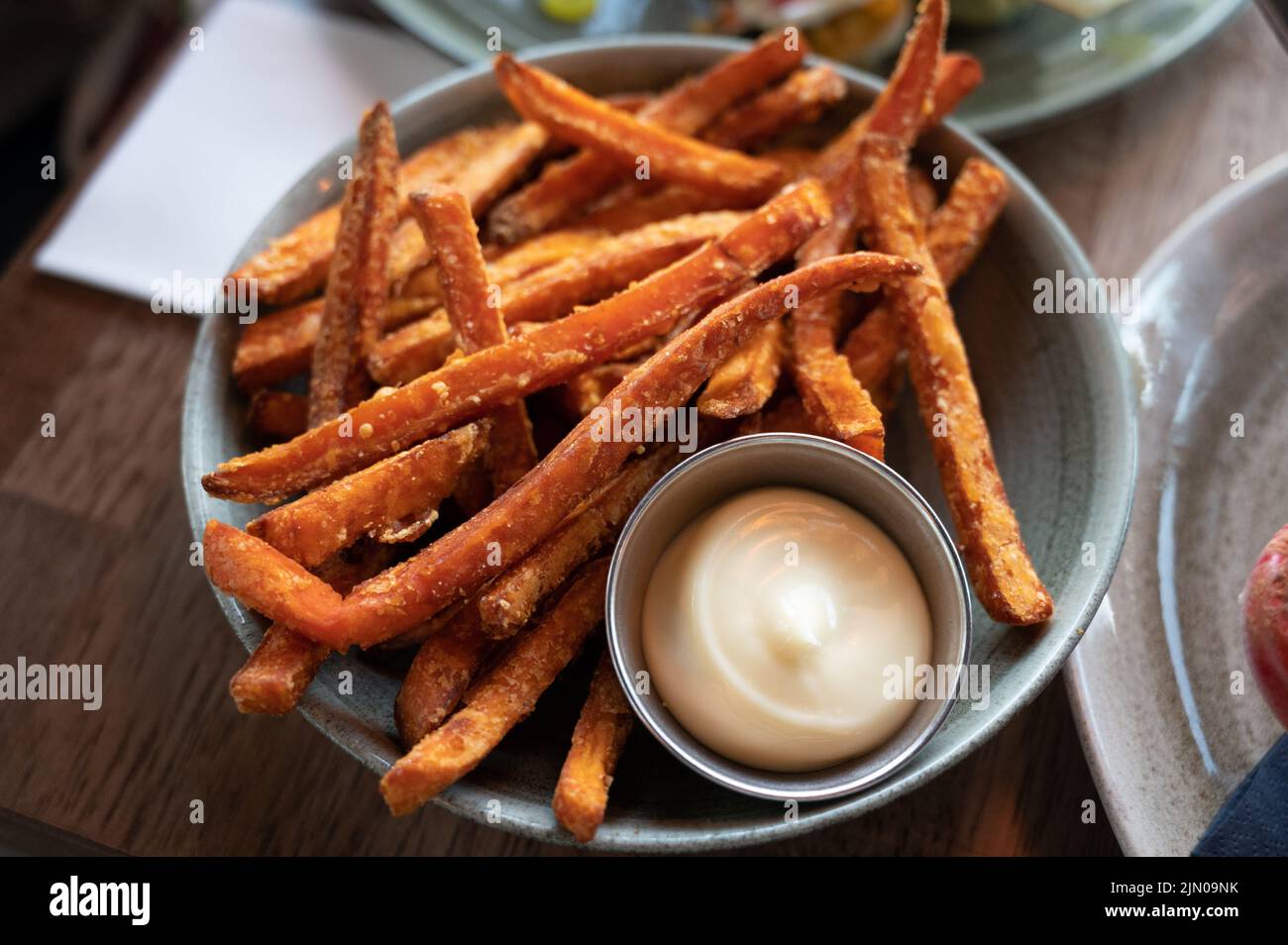 Bowl with tasty deep fried sweet potato chips served with mayonnaise
