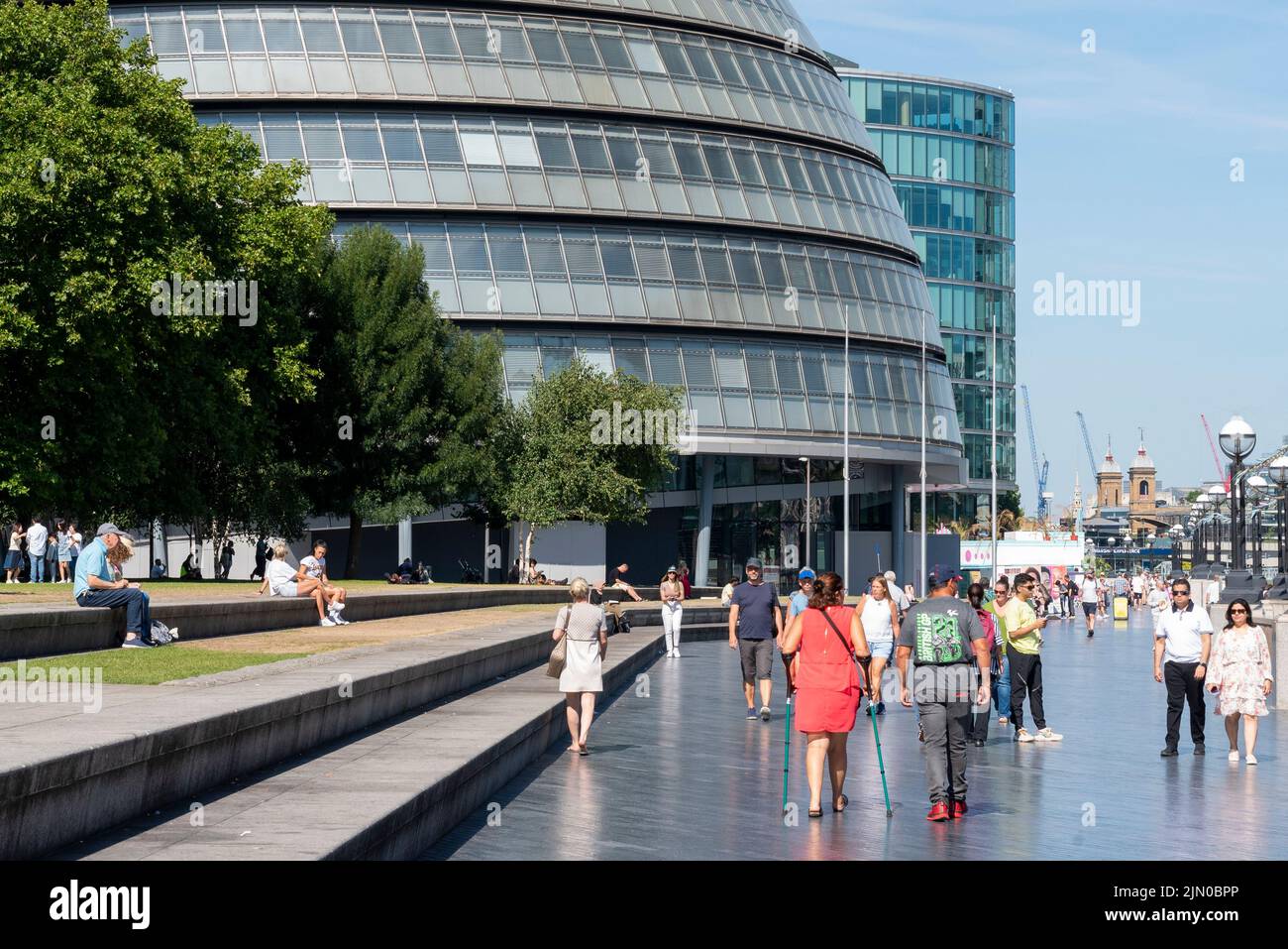 Tower of London, London, UK. 8th Aug, 2022. The hot weather has continued in the City. People enjoying the weather along the South Bank embankment opposite the Tower of London, near City Hall, the former Greater London Authority building Stock Photo
