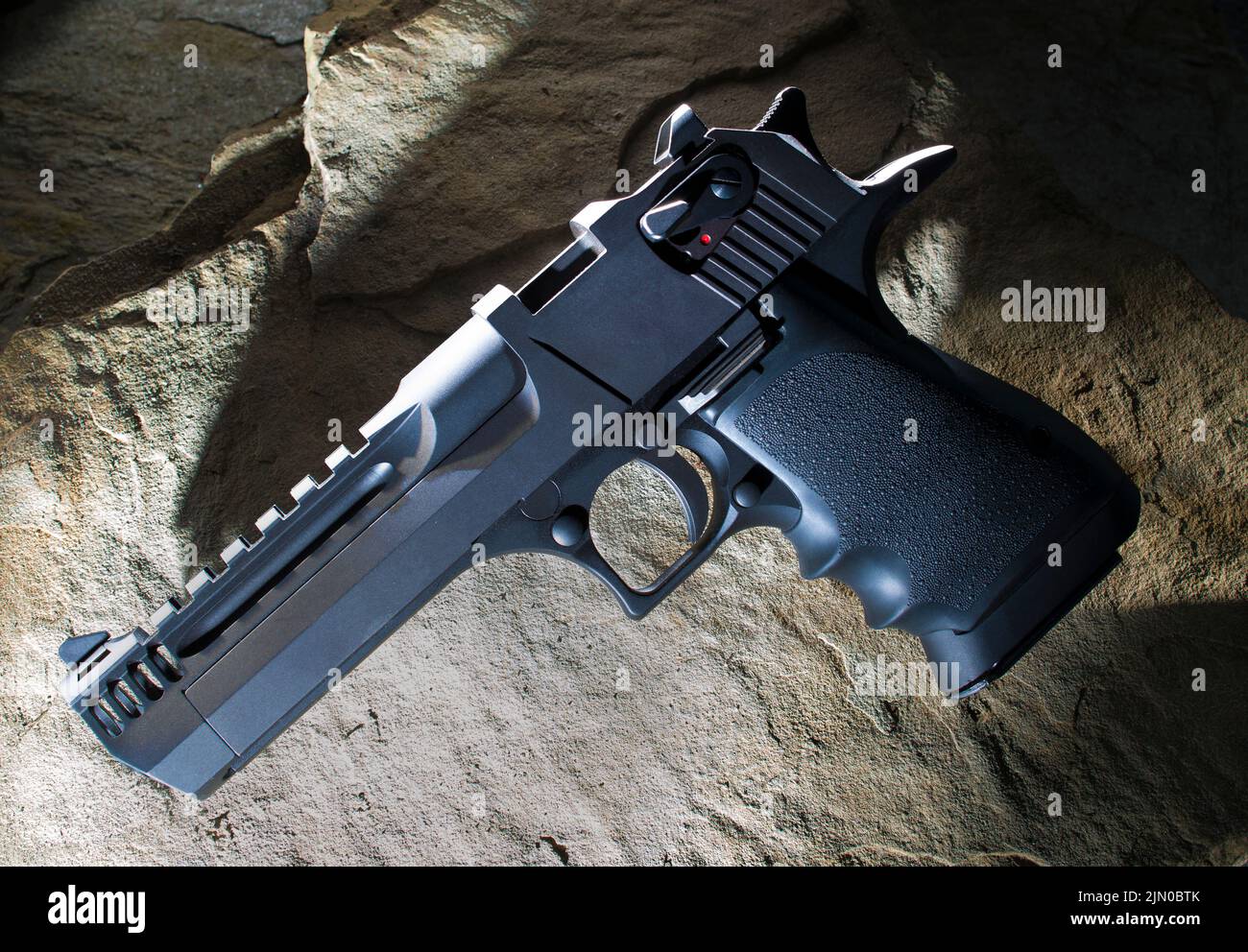 Large semi-automatic handgun on a brown stone background Stock Photo