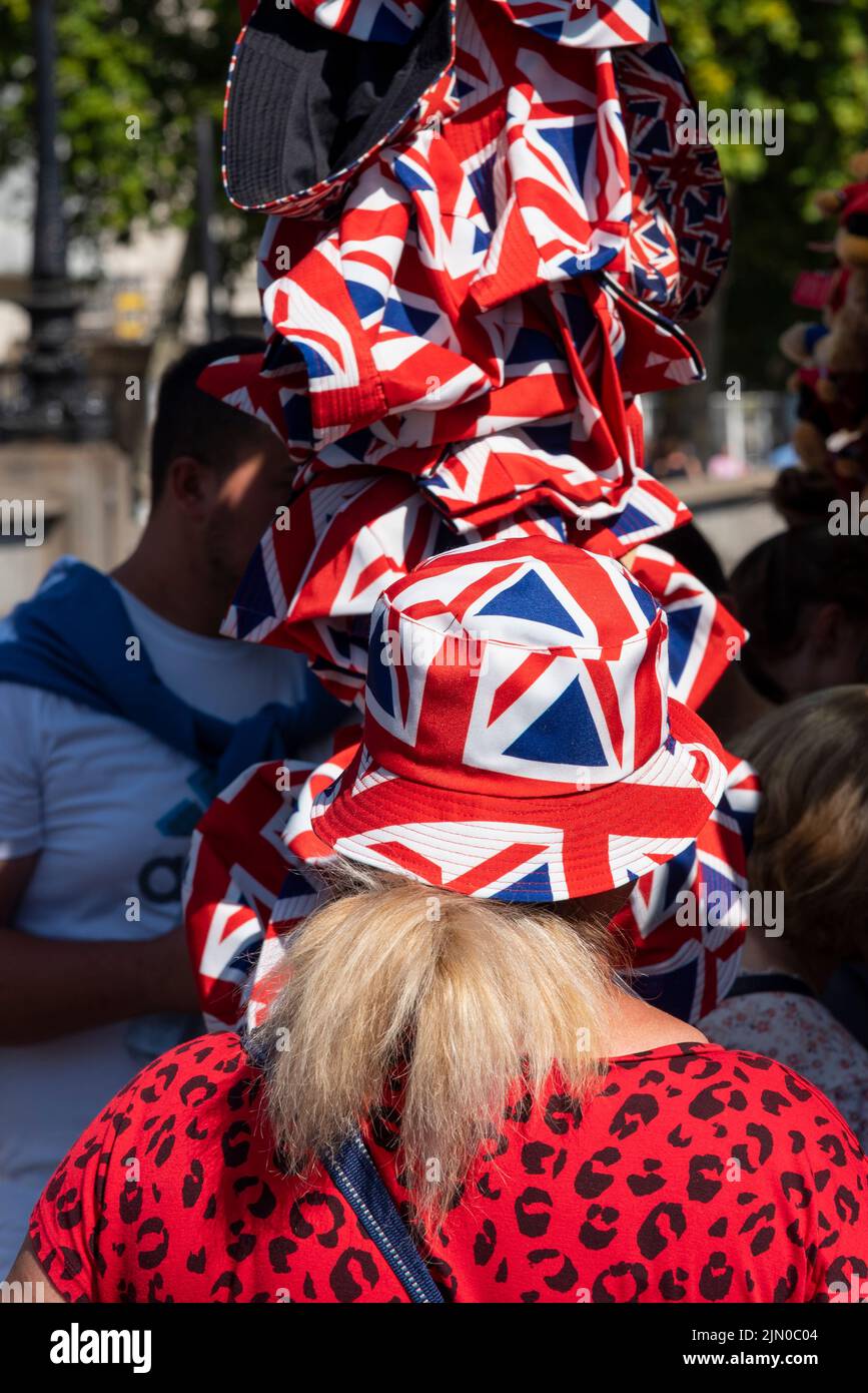 Westminster, London, UK. 8th Aug, 2022. The hot weather has continued in the City. A female tries on a Union Jack sun hat from the selection of hats Stock Photo