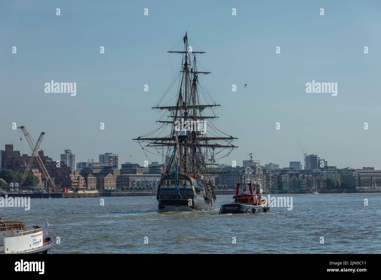 Swedish tall ship Gotheborg sailing on the River Thames towards Canary Wharf with a tug. Stock Photo