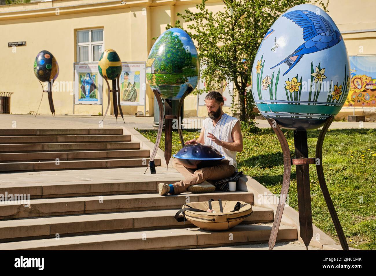 Street music performer playing some unique music with a handcrafted musical instrument called handpan. Stock Photo