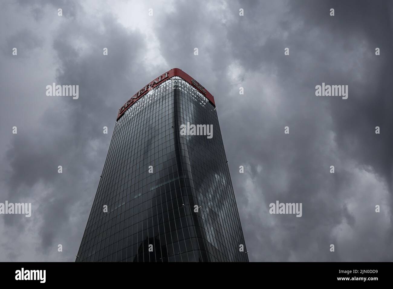 Milan, Italy - June 26, 2022: Generali Tower with Cloudy Sky in CityLife. Modern Skyscraper in Tre Torri. Dramatic Below View of Architecture in Milan Stock Photo