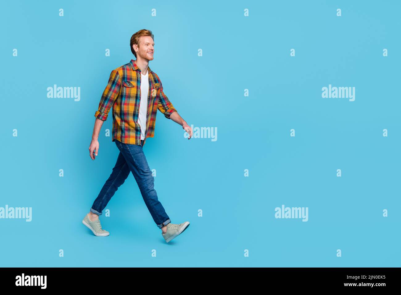 Full length photo of handsome man with ginger hair dressed stylish plaid shirt go shopping big sale isolated on blue color background Stock Photo