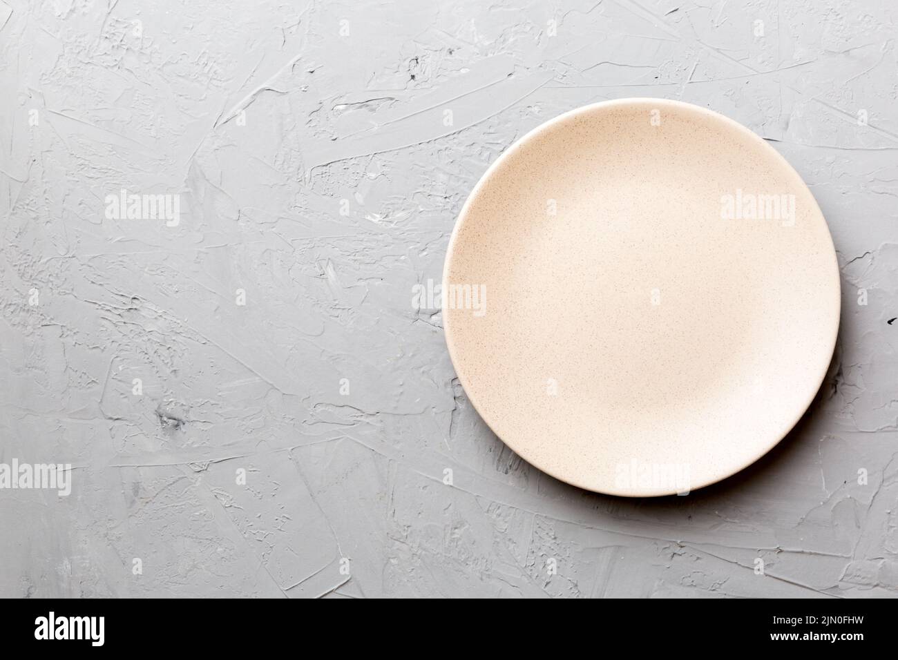 Top view of empty pink plate on cement background. Empty space for your ...