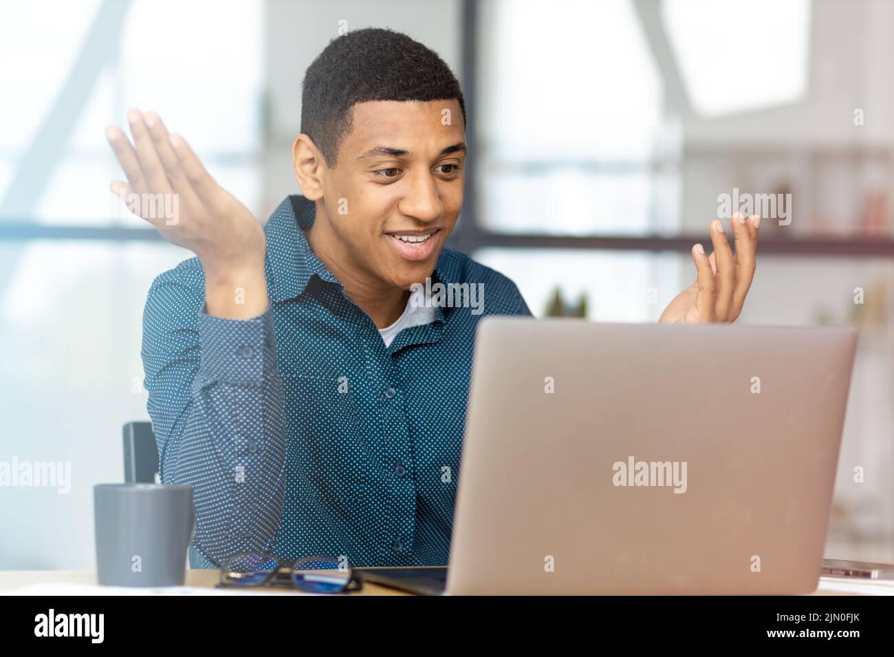 Man working using laptop Young businessman talking with colleagues or partners on video call Stock Photo