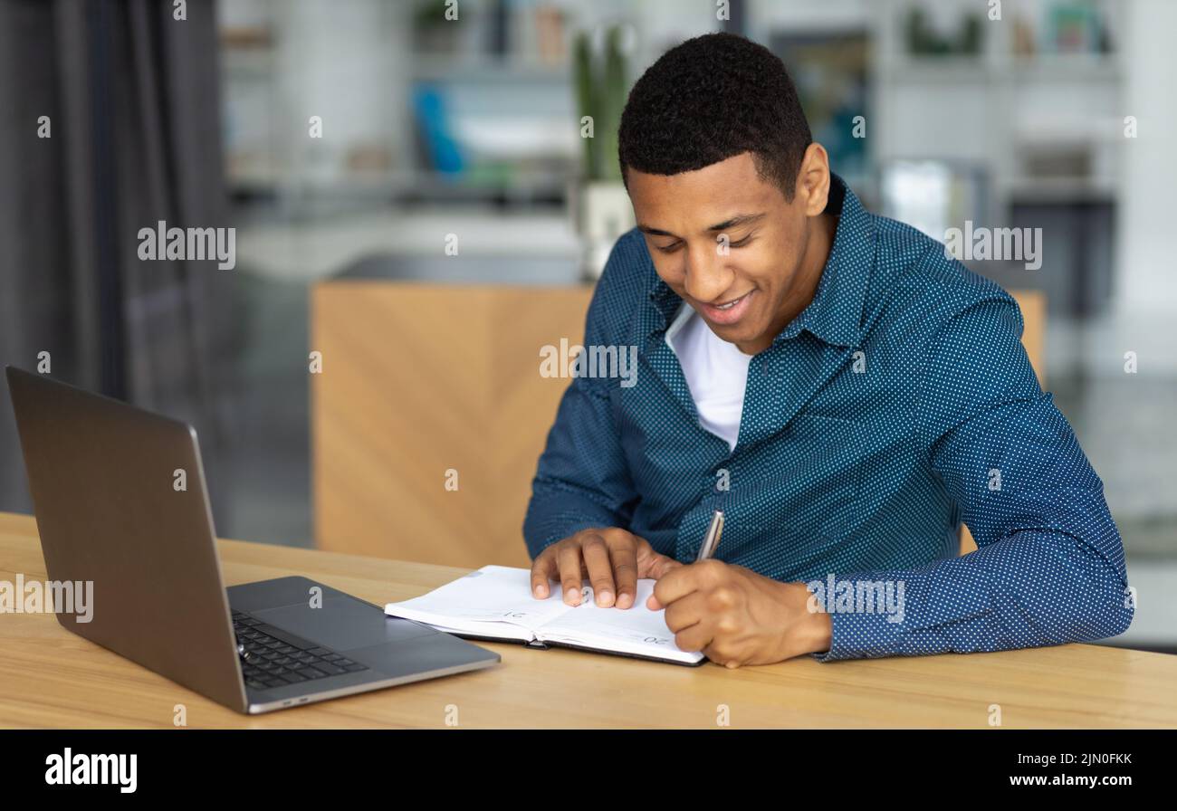 Confident young man Successful student working using laptop smiling friendly Stock Photo