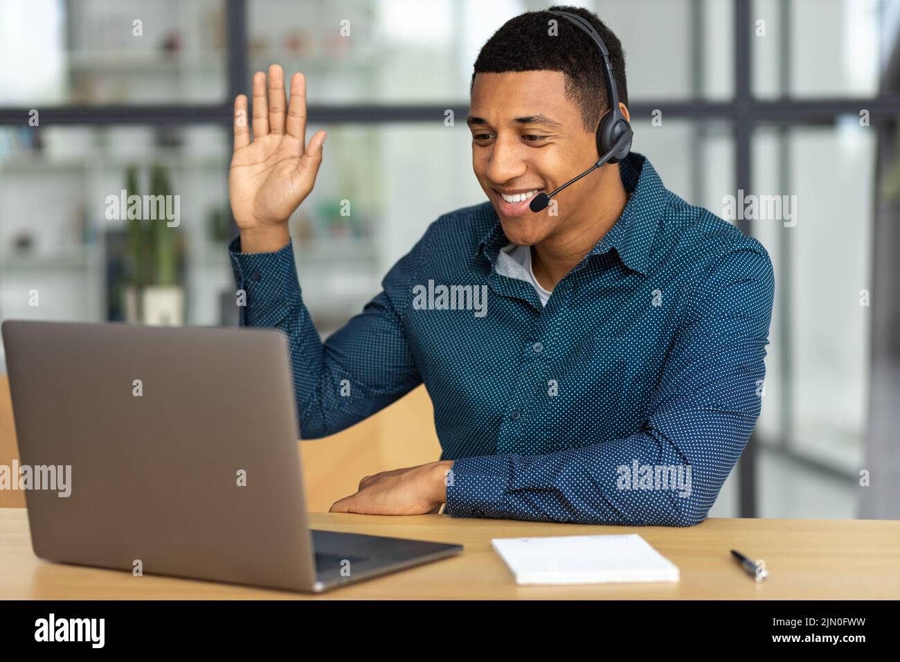 Successful man in headset office employee or call center worker talking consulting client using video call smile Stock Photo