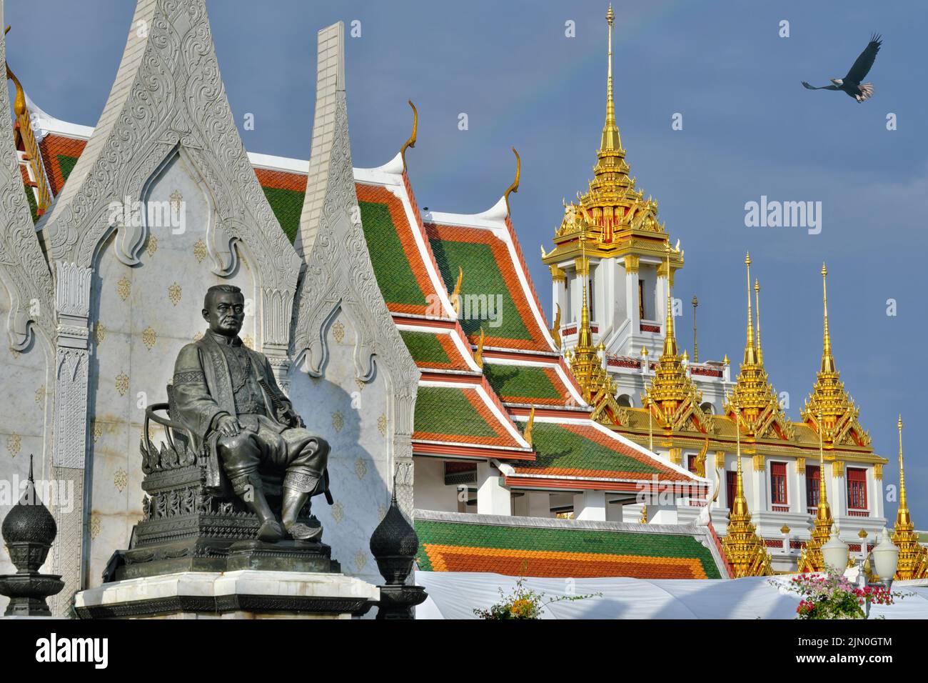 Rama III. Park with a statue of King Rama III., behind it Wat Ratchanatda (Ratchanatdaram), with the Lohaprasad behind on the right; Bangkok, Thailand Stock Photo