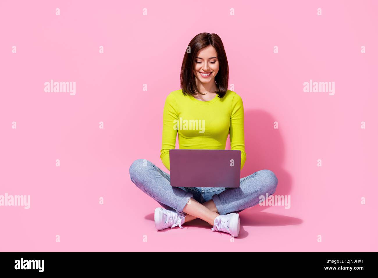 Photo of successful specialist lady sit use netbook colleagues communication isolated on pink color background Stock Photo