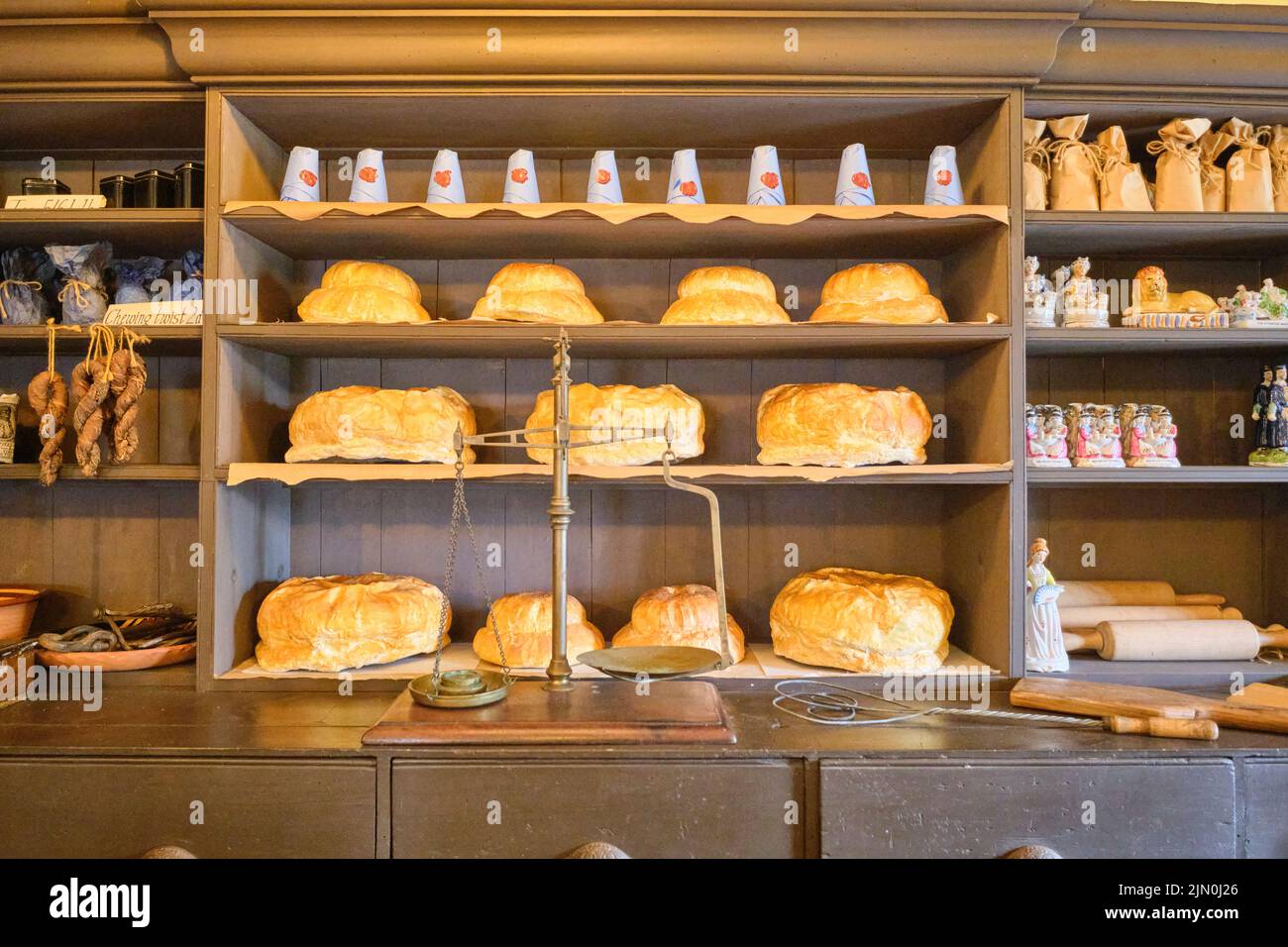 A scale with round loaves of bread on the shelves. In a recreation of