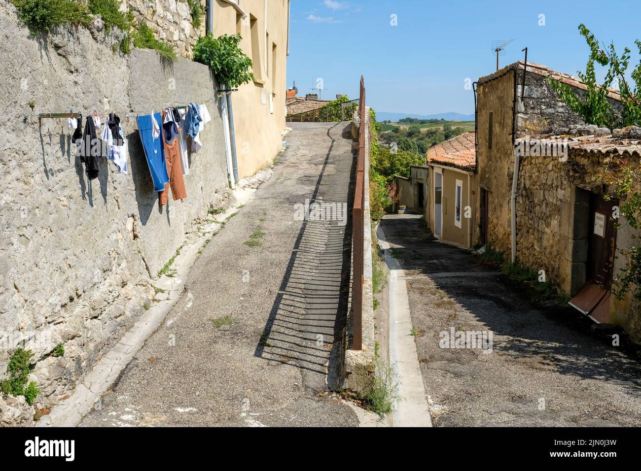 Washing dries on a pathway in the ancient commune of Aragon in South-East France. Stock Photo