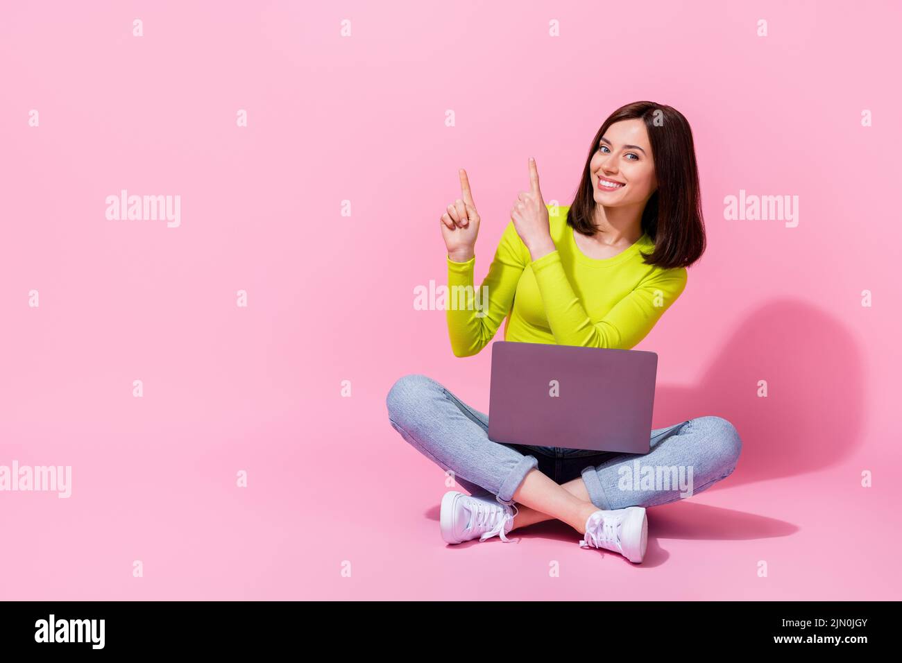 Photo of cute lady specialis tarm demonstrate offer distance work study use gadget device sit empty space isolated on pink color background Stock Photo