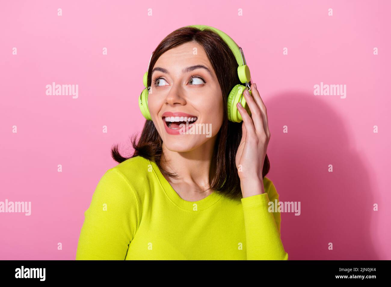 Photo of cheerful positive lady rejoice see announcement banner advert lovely band performance isolated on pink color background Stock Photo