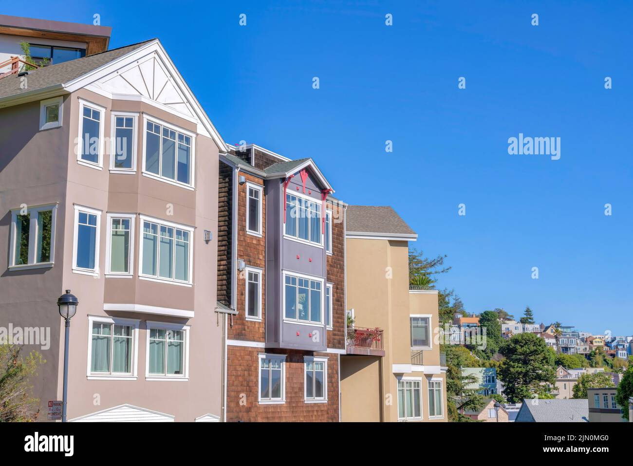 Row of four-storey houses with brown color scheme exterior at San Francisco, California. Three houses at the front of the neighborhood background with Stock Photo