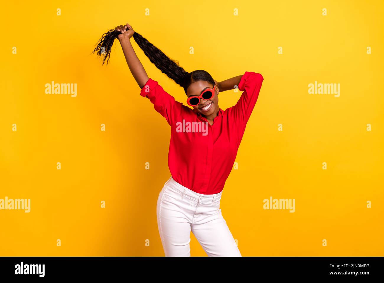Photo of young cheerful girl hand touch hair salon treatment eyewear isolated over yellow color background Stock Photo