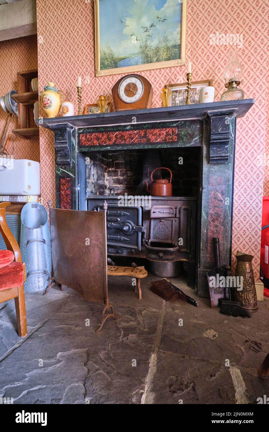 The fireplace with wrought iron cook stove and tea kettle with fire screen. In a recreation of a typical, generic worker's house, home from 1955 at Bl Stock Photo