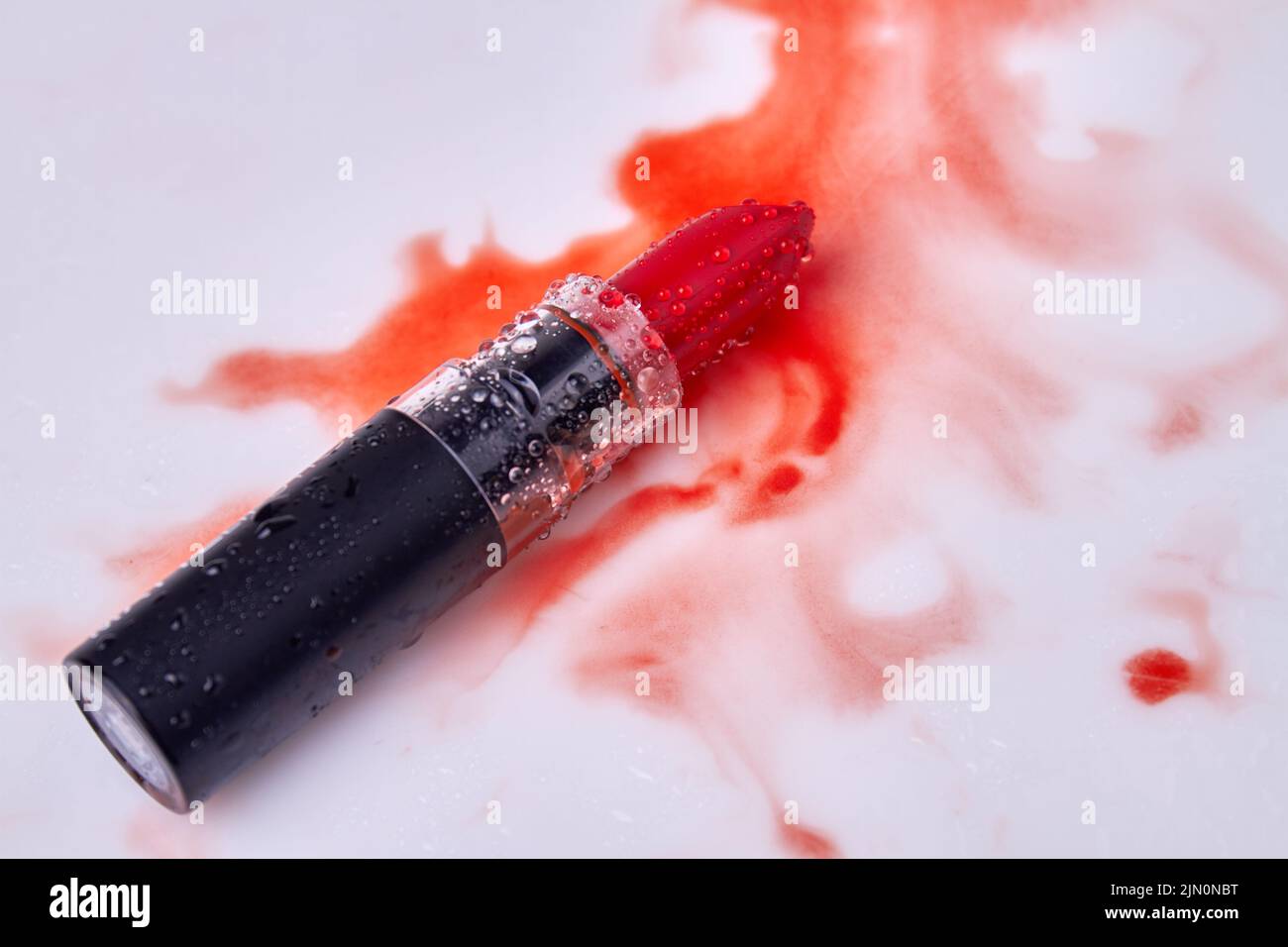 Lipstic with wet stains on white background. Make up cosmetic accessory. Stock Photo
