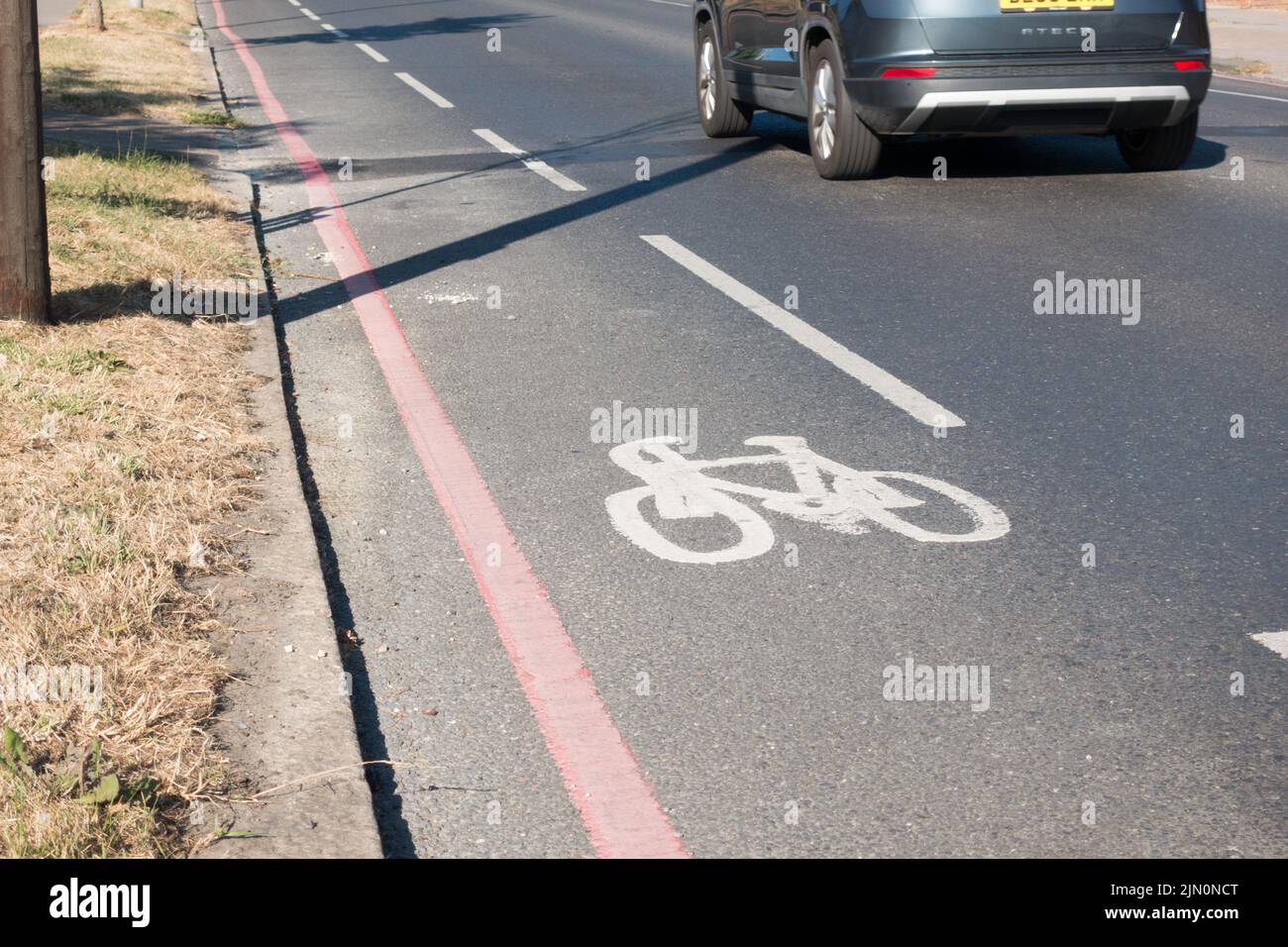 bicycle path painted on red route next to fast moving traffic Stock Photo